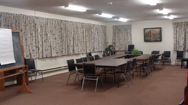 The Herzog Room features a large rectangular table surrounded by chairs and includes a chalkboard.