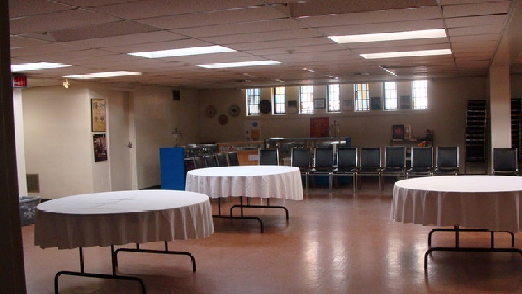 Interior of the Tomarin Room featuring several round tables with white tablecloths and chairs arranged nearby.