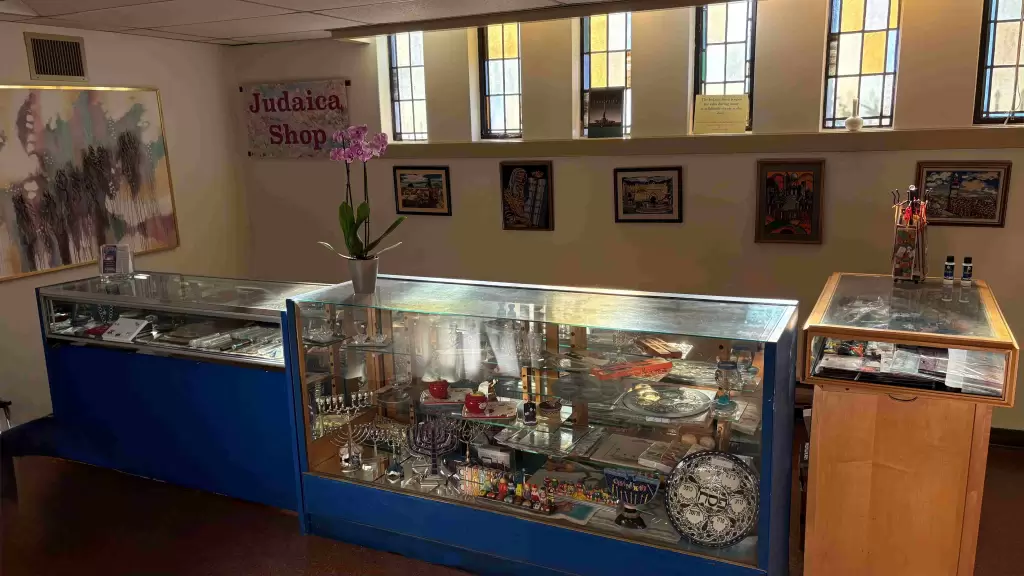 A view of the gift shop in the Tomarin Room, featuring display cases with various items and artwork on the walls.